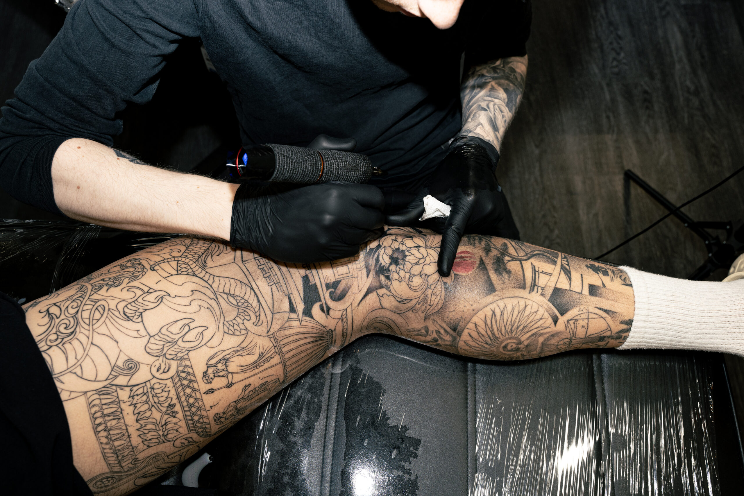 [tattoo artist arbejder på sleeve tatovering fokuseret og kvalitetsbevidst i Aarhus dagssession]